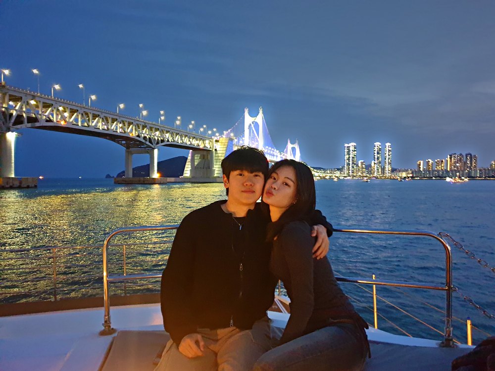 以夜景为背景乘坐游船的情侣