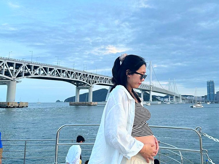 以广安大桥为背景站在甲板上的游客